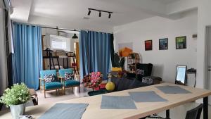 a living room with a table and blue chairs at IM Santai Lodge in Kangar