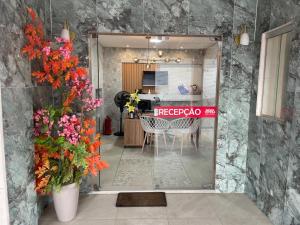 ein Zimmer mit einem Tisch und Stühlen und Blumen in der Unterkunft Hotel Cintra in Arcoverde
