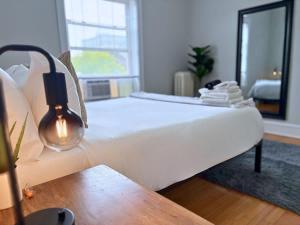 a large white bed in a room with a lamp at Charming 1BR Apt in Evanston - Hinman B3 in Evanston