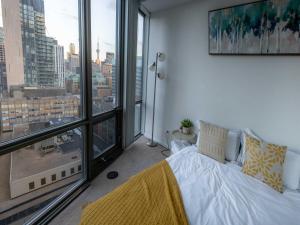 a bedroom with a bed and a large window at Urban Skyline in Toronto