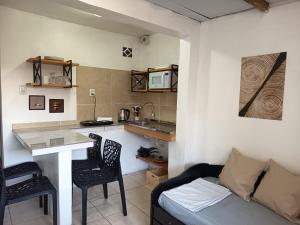 a living room with a couch and a table and a kitchen at Residencial Ponta Norte -Ponta das Canas in Florianópolis