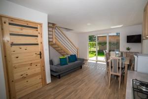 un soggiorno con un divano e un tavolo di Comfortable, two-story holiday home, summer pool a Jarosławiec