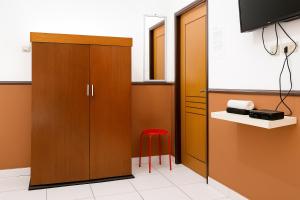 a room with a cabinet and a red stool at Citytel Kostel in Lampung