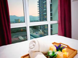 イポーにあるIpoh City Centre Majestic 2 Room Condo near Gerbang Malam by City Home Empireの窓の前の花壇の上に置かれた花の入ったトレイ