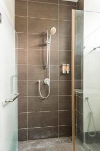 a bathroom with a shower with a glass door at Holiday Home By Island Hospitality in Teluk Bahang