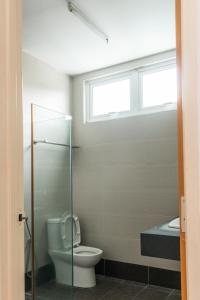 a bathroom with a toilet and a sink and a window at Holiday Home By Island Hospitality in Teluk Bahang