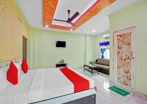 a bedroom with a bed and a ceiling fan at Collection O Pink House in Madhyamgram