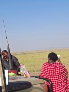 two people sitting at a table in the back of a car at Maasai homestay camping in Sekenani