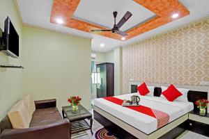 a hotel room with a bed and a chair at Collection O Pink House in Madhyamgram