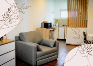 a living room with a chair and a kitchen at CerroSur in Yacimiento Río Turbio