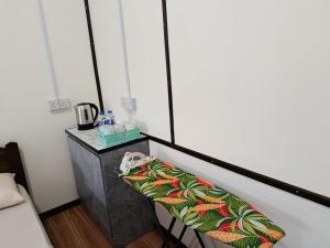 a room with a bed and a table with a phone at Dongorit Cabin 2 in Kampong Kundassan