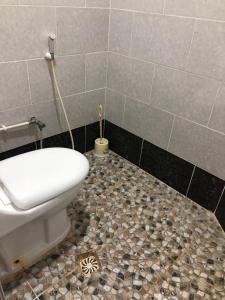 a bathroom with a toilet and a tiled floor at Appartement en bord de mer 3 chambres in Aguemoun Taïda +3 photos