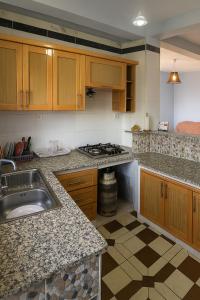 a kitchen with a sink and a stove in it at Appartement en bord de mer 3 chambres in Aguemoun Taïda