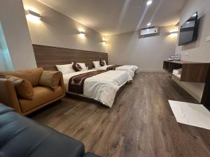 a bedroom with a large bed and a couch at Aurora Đồng Văn Boutique Hotel in Dồng Văn