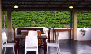 a table and chairs on a porch with a view of a field at Tea sprig villa in Boralanda