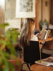香南市にあるゲストハウス コワーキングスペース kuzume Base TOMARUKUの机に座って本を読む女性 +39枚の写真