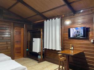 a bedroom with a bed and a table and a window at Camping e Pousada Maloca e Rodas in Alter do Chao