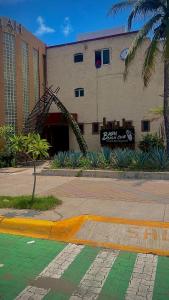 a building with a palm tree in front of it at Baru Beach Club & Hotel in Manzanillo
