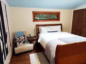 Un dormitorio con una cama y una silla y una ventana. en -Fall SALE Upscale GetAway at BEACH,KAYAKS,SPA,Sauna, en Forestville 29 fotos más