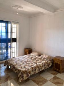 a bedroom with a bed and a large window at Appartement en bord de mer 3 chambres in Tizouiar