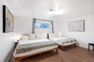 una camera da letto con due letti e una finestra di Cozy Basement 1 BR Suite King & Queen Beds, Sleeps 6, Street Parking a Burnaby