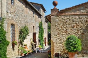 an alley in an old stone building with plants at Charming House in Tuscany with Pool & Views in Sovicille