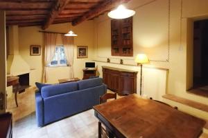 a living room with a blue couch and a table at Charming House in Tuscany with Pool & Views in Sovicille