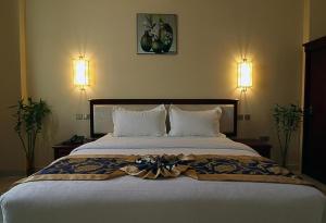 马斯喀特Farah Hotel Apartment的一间卧室配有一张大床,上面有弓