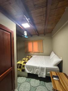 a small bedroom with a bed and a table at La Casa Naranja Bed and Breakfast in Olón