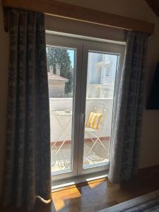 a sliding glass door with a chair on a balcony at House of Mimoza in Shkodër