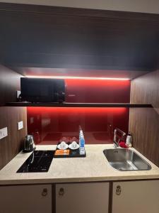 ムイネーにあるApec mandala Apartment - APEC Mandala Ocean View Mui Neの赤い壁のキッチン(シンク、コンロ付) +48枚の写真