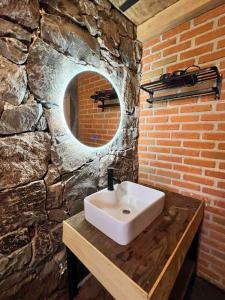 a bathroom with a sink and a stone wall at Cozy cabin in the woods with a wooden tub in Huasca de Ocampo +31 photos