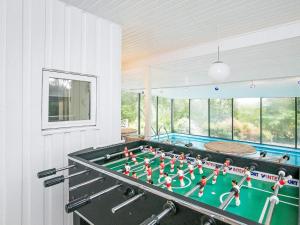 a ping pong table in a room with a pool at 8 person holiday home in Farsø-By Traum in Ertebølle