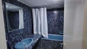 La salle de bains est pourvue d'un lavabo bleu et d'une baignoire. dans l'établissement Spacious Apartment in the heart of downtown Fez, à Fès