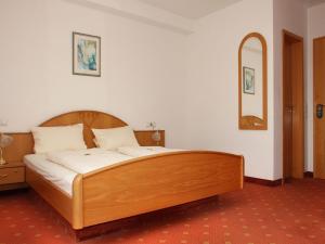 a wooden bed in a room with a mirror at Gasthof Rössle in Vogtsburg