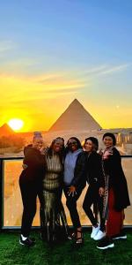 a group of people standing in front of the pyramids at The Heaven Pyramids View in Cairo