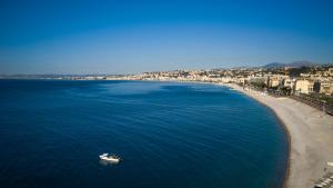a boat in the water next to a beach at Hotel Suisse in Nice
