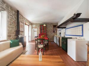 a kitchen and living room with a couch and a table at Rustic Chalet with Pool in San Marcello Pistoiese