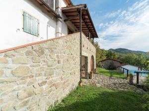 an external view of the house with a stone wall at Rustic Chalet with Pool in San Marcello Pistoiese
