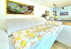 a couch with a floral blanket on it in a living room at 15 Min Center Terrace BBQ Luxury Cinem Quiet in Trierweiler