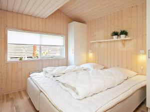 a large white bed in a room with a window at Idyllic Marina Retreat - By Traum Ferienwohnungen in Tranekær