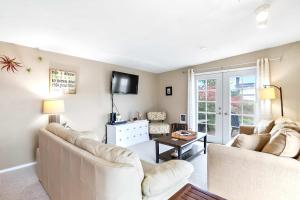 a living room with two white couches and a tv at Charming Cottage by Creek & Ocean in Blaine