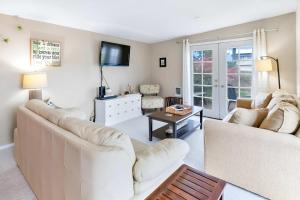 a living room with two white couches and a tv at Charming Cottage by Creek & Ocean in Blaine