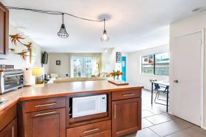 an open kitchen with a microwave and a table at Charming Cottage by Creek & Ocean in Blaine