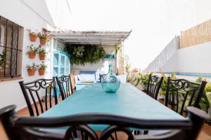 een tafel met stoelen en een vaas erop bij La Casa Azul in Alquerías del Niño Perdido