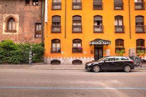 un coche negro estacionado frente a un edificio amarillo en Hotel Ares Milano en Milán