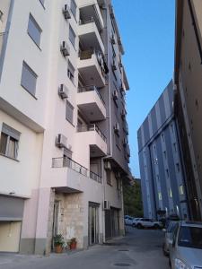 an apartment building with balconies and a parking lot at Apartman Martina 3 in Rafailovici