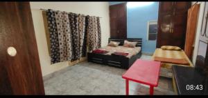 sala de estar con cama y silla roja en Mahadevi Mataji Ashram, en Varanasi
