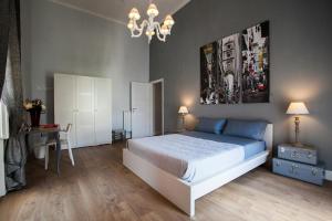 1 dormitorio con cama, mesa y lámpara de araña en Largo Donnaregina Home, en Nápoles