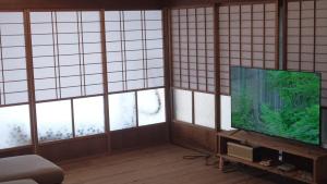 a room with a flat screen tv and windows at オワセベースowase base in Owase